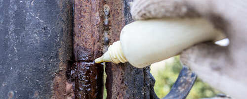 lubricating-of-rusty-gate-hinge-with-oil-outdoors-2024-10-17-07-19-52-utc(2)